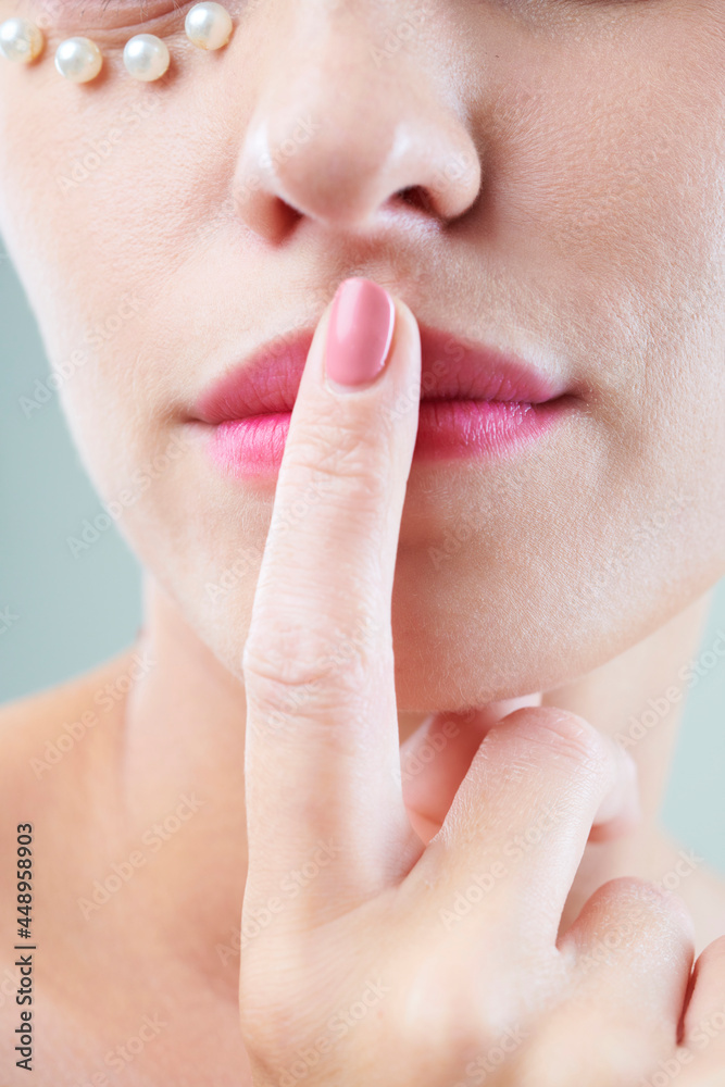 Close-up of young woman touching pink lips with finger Close-up of young woman touching pink lips with finger