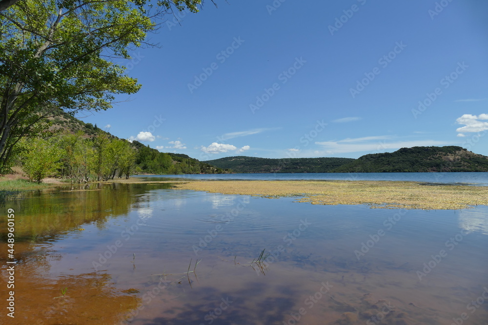 panoramic view of lake with reflection under blue sky picturing harmony and tranquility with copy space in sky