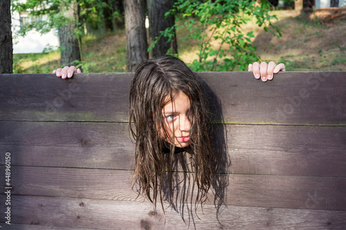 the head of a girl with long disheveled hair clamped in a guillotine, a scene of a medieval execution, a sentence photo