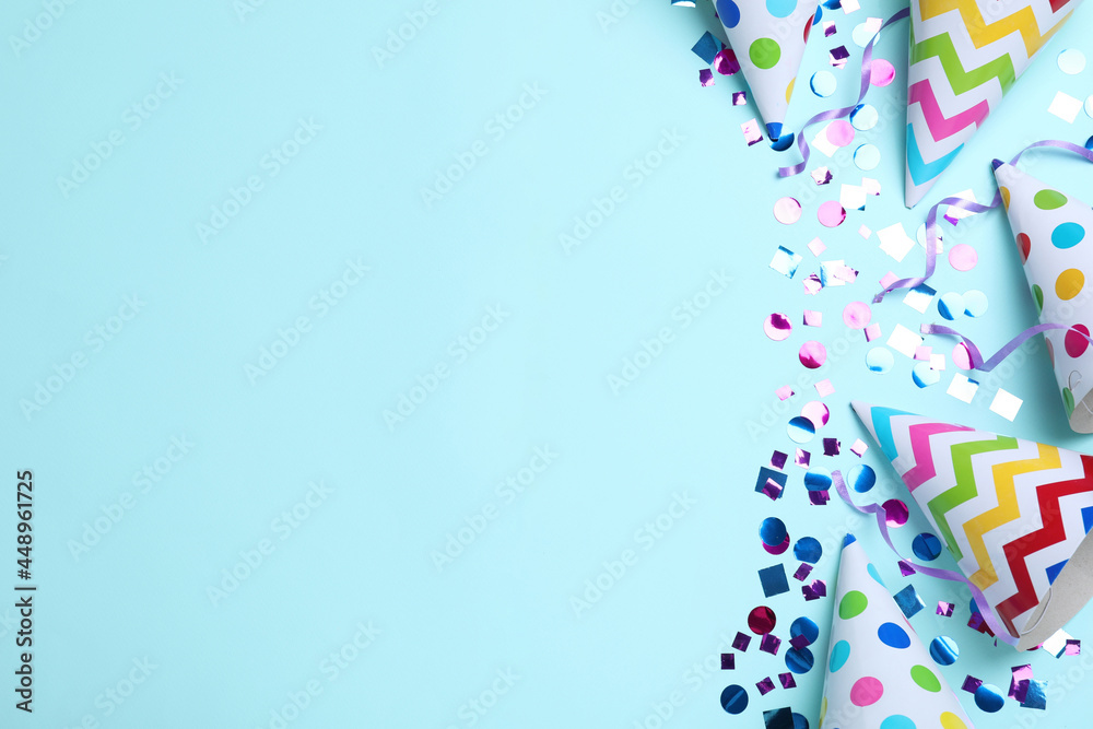 Flat lay composition with party hats and confetti on light blue background, space for text. Birthday items Flat lay composition with party hats and confetti on light blue background, space for text. Birthday items