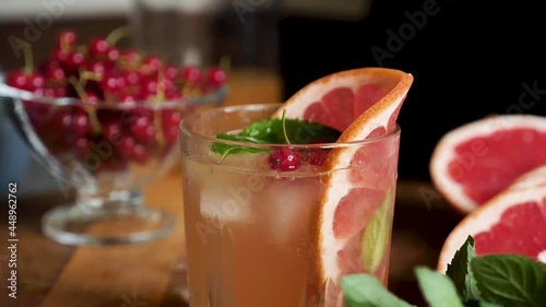 Wallpaper Mural Currant falls into grapefruit lemonade with ice in a glass close up in slow motion. Making a summer refreshing drink Torontodigital.ca