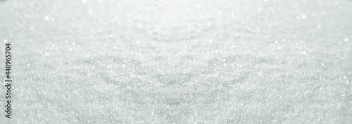 Snow crystals on soft winter backround. Horizontal close-up with short depth of field and space for text. Winter and christmas background.