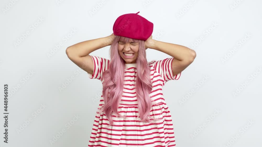 Young woman with pink hair covering both ears with hands. Frustrated expression over isolated background Young woman with pink hair covering both ears with hands. Frustrated expression over isolated background