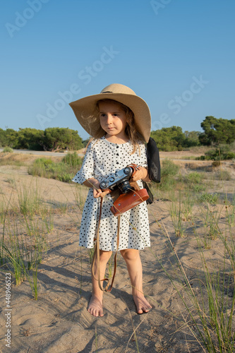 Cute little girl takes pictures of nature.