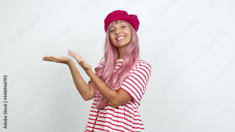 Young woman with pink hair extending hands to the side and inviting to come over isolated background Young woman with pink hair extending hands to the side and inviting to come over isolated background