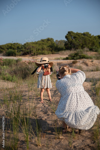 Mom and daughter are photographed on the beach