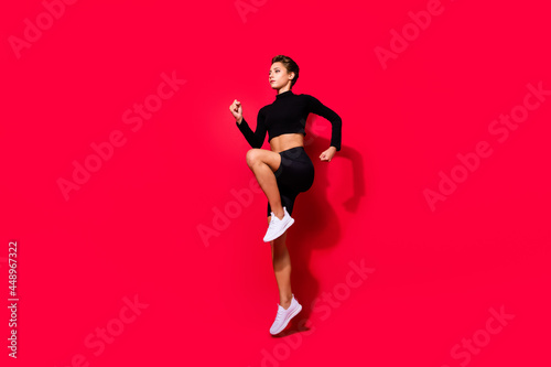 Profile photo of runner serious lady jogging training wear black cropped top isolated red color background