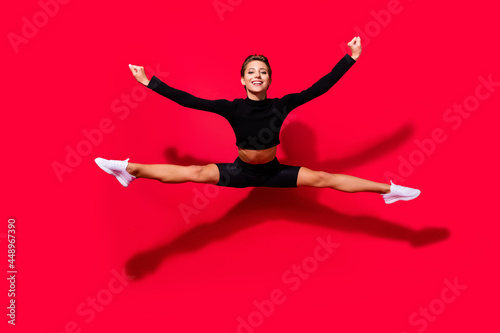 Photo of active energetic cheerful lady jump enjoy flight wear black cropped top isolated red color background
