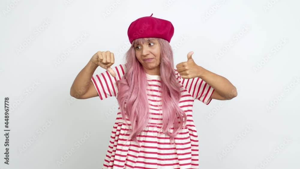 Young woman with pink hair making good-bad sign over isolated background Young woman with pink hair making good-bad sign over isolated background
