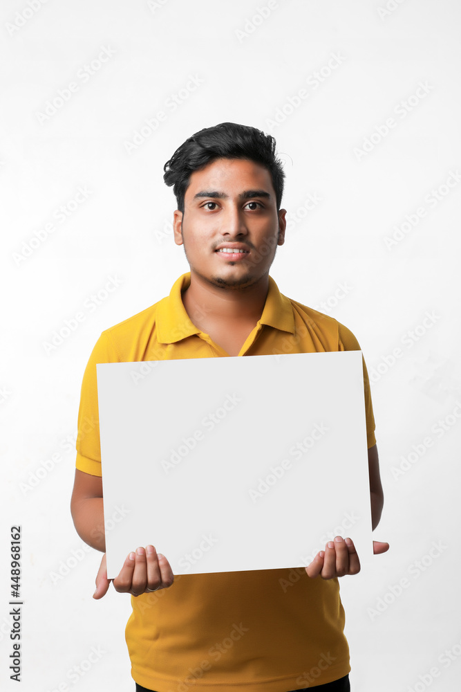 Young indian college student showing white board on white background Young indian college student showing white board on white background