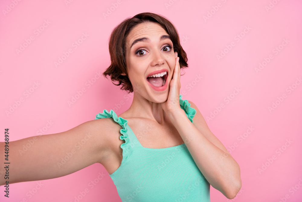 Photo of astonished brown hairdo millennial lady do selfie wear teal top isolated on pink color background Photo of astonished brown hairdo millennial lady do selfie wear teal top isolated on pink color background