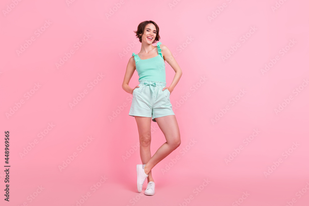 Full body photo of funky short hairdo young lady stand wear teal top shorts isolated on pink color background Full body photo of funky short hairdo young lady stand wear teal top shorts isolated on pink color background