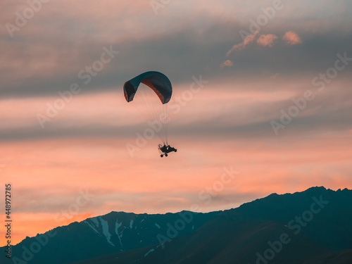 Extreme sports. Powered parachute over the mountains at sunset.