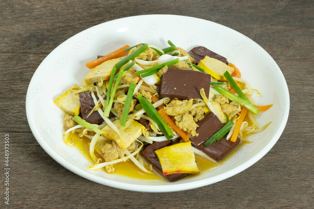 Stir Fried Bean Sprouts in white ceramic plate. Stir fried bean sprouts with yellow tofu, ground pork, carrots, pig's blood and shallot. Thai food. Stir Fried Bean Sprouts in white ceramic plate. Stir fried bean sprouts with yellow tofu, ground pork, carrots, pig's blood and shallot. Thai food.