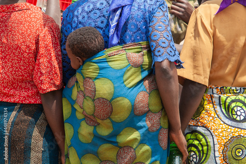 african woman colorful clothings carrying baby