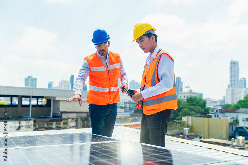 Foreman and Worker maintaining solar energy panel. The supervisor is explaining the installation of the solar panel to the young worker. Foreman and Worker maintaining solar energy panel. The supervisor is explaining the installation of the solar panel to the young worker.