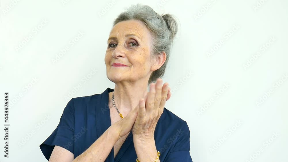 Beautiful old funny grandmother with grey hair and face with wrinkles is grimacing while looking at the camera on white background, mothers day, happy retirement