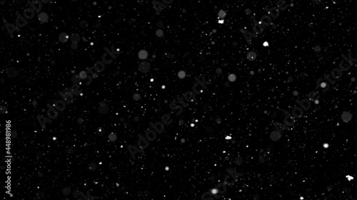 Bokeh of white snow on a black background. Falling snowflakes on night sky background, isolated for post production and overlay in graphic editor.