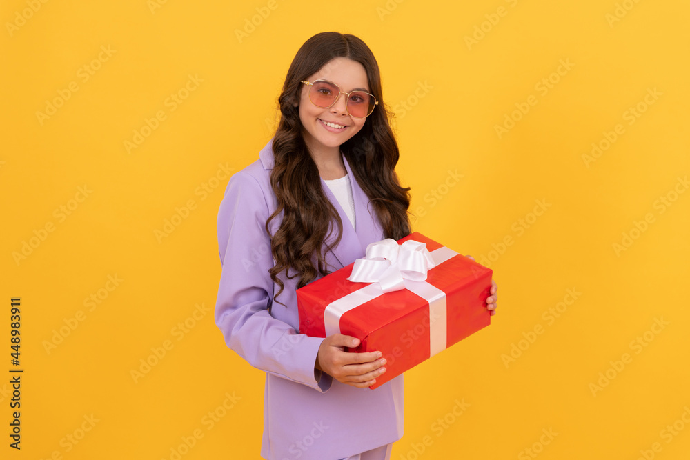 trendy cheerful teen girl in sunglasses and suit hold present box on yellow background, boxing day trendy cheerful teen girl in sunglasses and suit hold present box on yellow background, boxing day