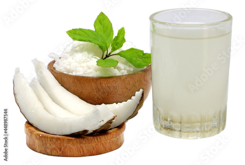 Sliced Coconut and water in a glass with mint over white background