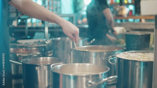 Soup is being stirred in the cooking pot