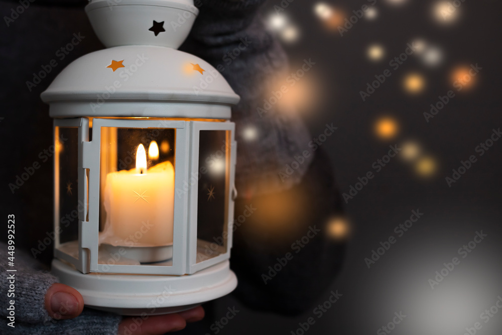 Female hands hold a flashlight with a burning candle inside. Female hands hold a flashlight with a burning candle inside.