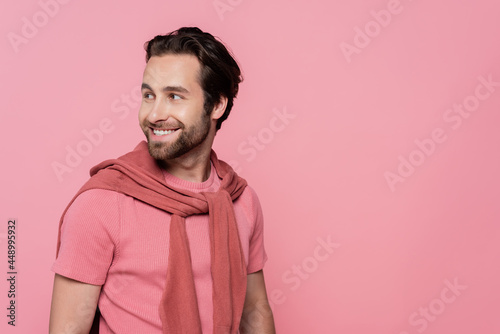 Cheerful man in t-shirt looking away isolated on pink