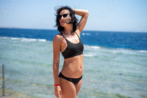 Beautiful smiling woman chilling on the beach alone 