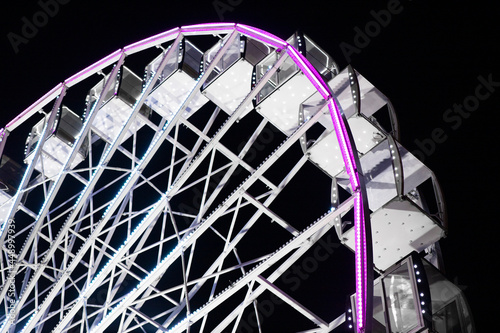 Ferris wheel glows at night. Big Ferris wheel.