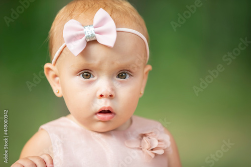 Quadro su tela The face of a beautiful little girl on a green background