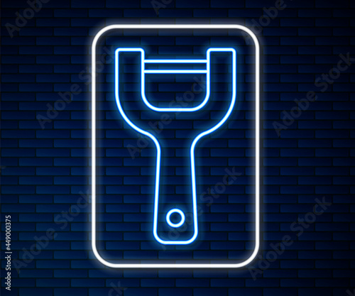 Glowing neon line Vegetable peeler icon isolated on brick wall background. Knife for cleaning of vegetables. Kitchen item, appliance. Vector