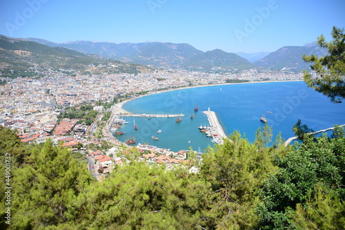Alanya harbour with ships and lighthouse and city with streets view from top of mountain