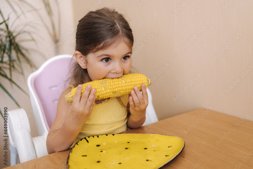 Adorable little girl eating corn at home. Cute kid tree year old eat boild corn Adorable little girl eating corn at home. Cute kid tree year old eat boild corn