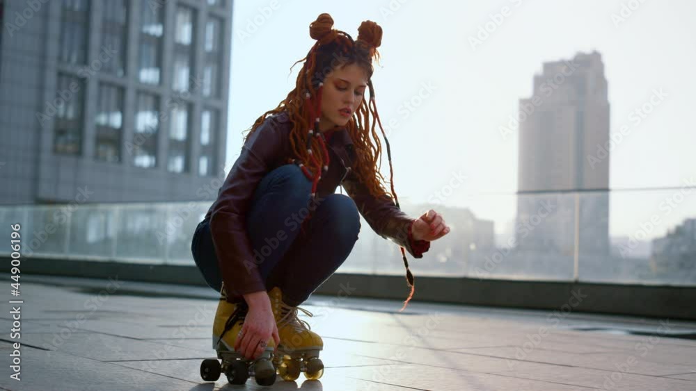 Roller skater doing trick on roof. Woman legs riding on skates outside.