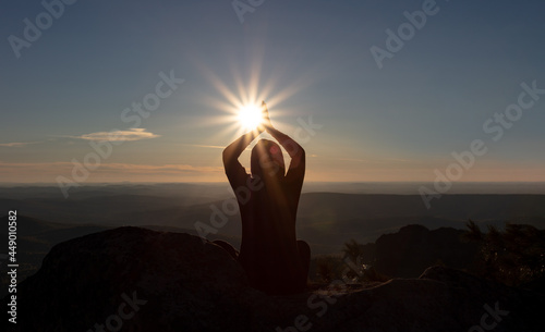 a girl meditates on the top of a mountain at sunrise, sunset. mountain trekking, climbing, yoga in autumn or spring. active recreation. the energy and rays of the sun for human nutrition. HIRES