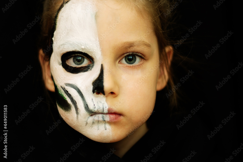 a girl in Halloween makeup in the image of a dead man with a white and black skull.