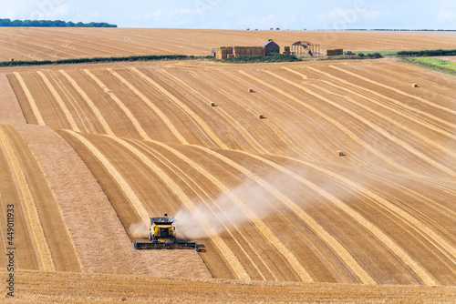 Crop havesting on a dry sunny day with farm buildings