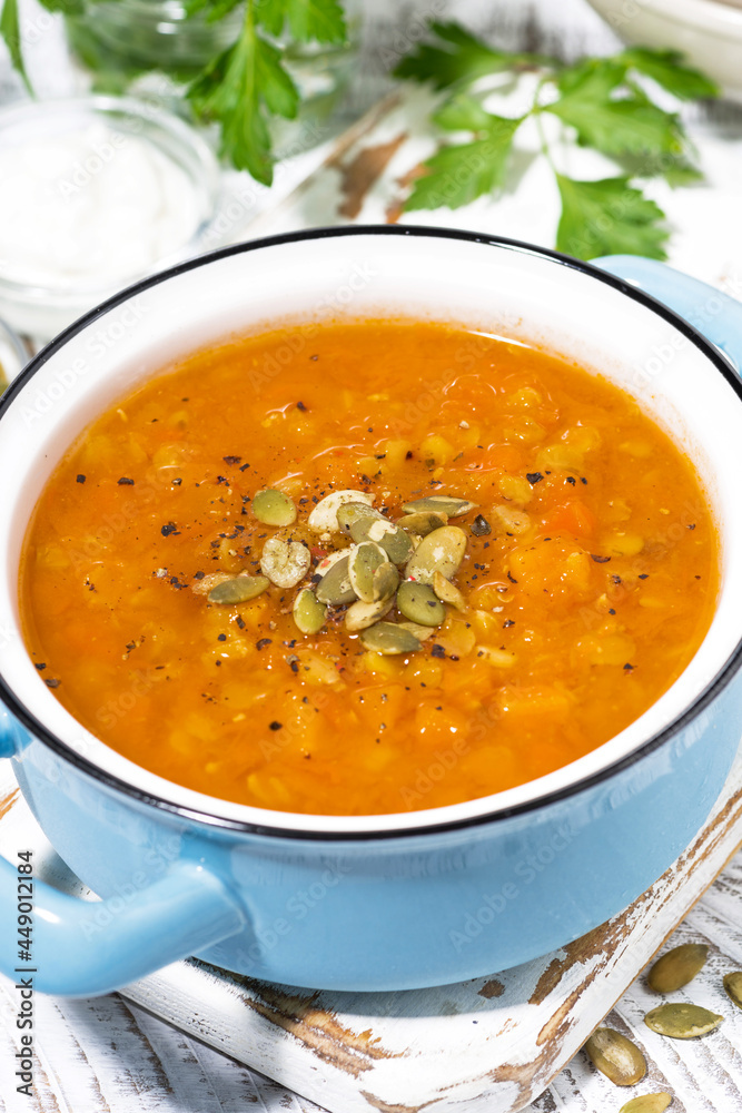healthy lunch. spicy pumpkin soup with lentils in a saucepan, vertical closeup