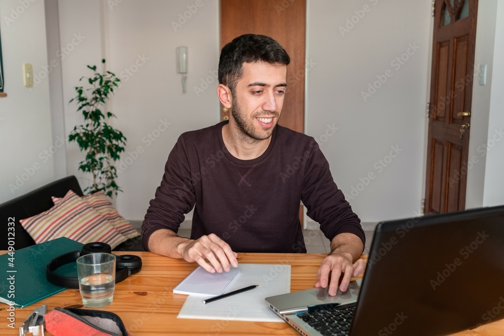 Happy man working at home on his laptop