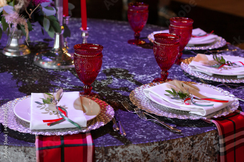 The table is served with red glasses. The plate is decorated with flowers