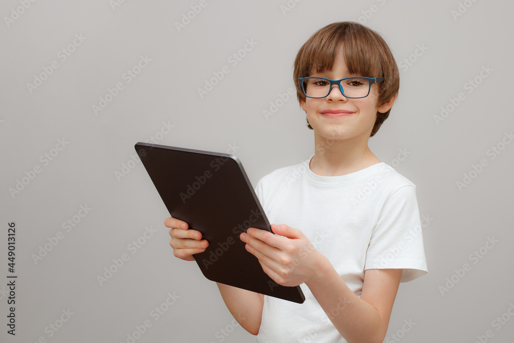 Smiling boy in white t-shirt wearing glasses with tablet Smiling boy in white t-shirt wearing glasses with tablet
