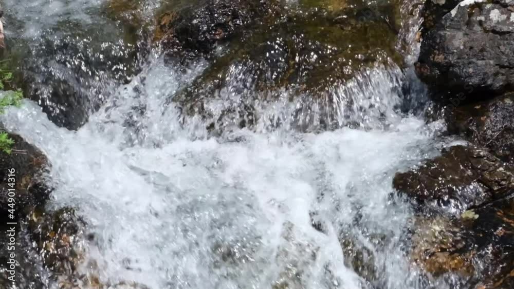 Wild mountain river. A stream with clear clear water and boulders close-up. Slow motion Wild mountain river. A stream with clear clear water and boulders close-up. Slow motion