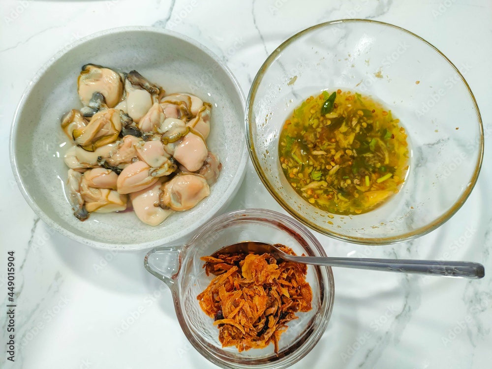Oyster and side dishes in Thai style, Thai style oysters with spicy dipping sauce. Stock Photo