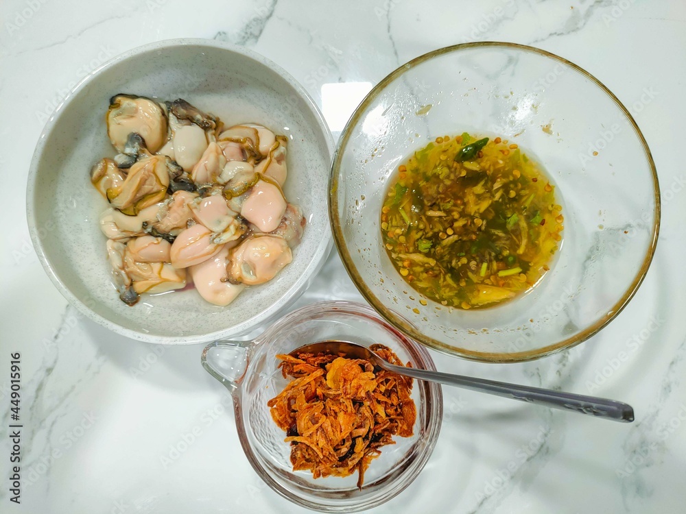 Oyster and side dishes in Thai style, Thai style oysters with spicy dipping sauce. Stock Photo