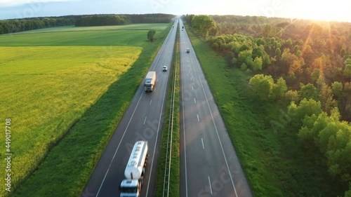 Aerial view of the highway among green fields in spring