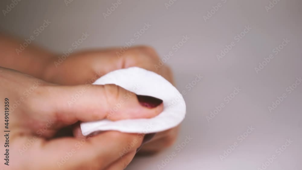 Woman removes red nail polish with nail polish remover. Lady removes the nail polish. Woman hand removing red nail polish with white cotton pad Woman removes red nail polish with nail polish remover. Lady removes the nail polish. Woman hand removing red nail polish with white cotton pad