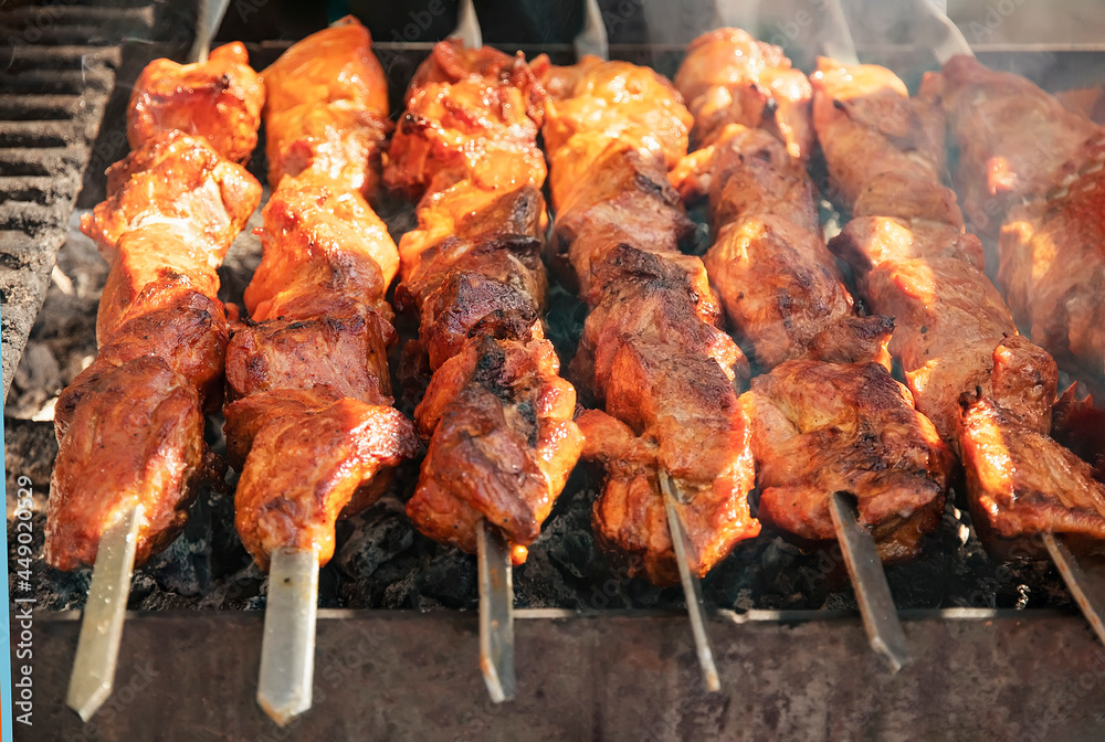 delicious barbecue grilled on an open fire on an open kitchen. Food festival in the city on the street. Pork fried on a skewer on a food court for a summer picnic. Grilled shish kebab.