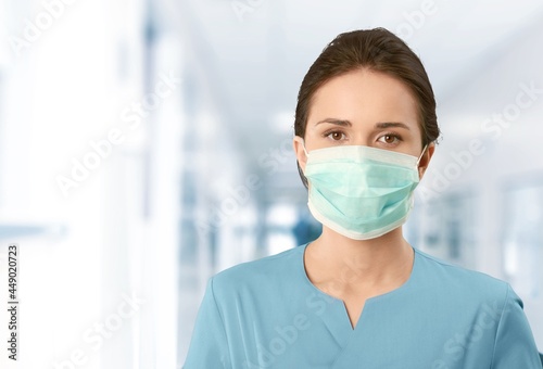 Female doctor with face mask on hospital background