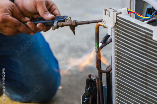 Air Conditioning Repair use fuel gases and oxygen to weld or cut metals, Oxy-fuel welding and oxy-fuel cutting processes, repairman on the floor fixing air conditioning system