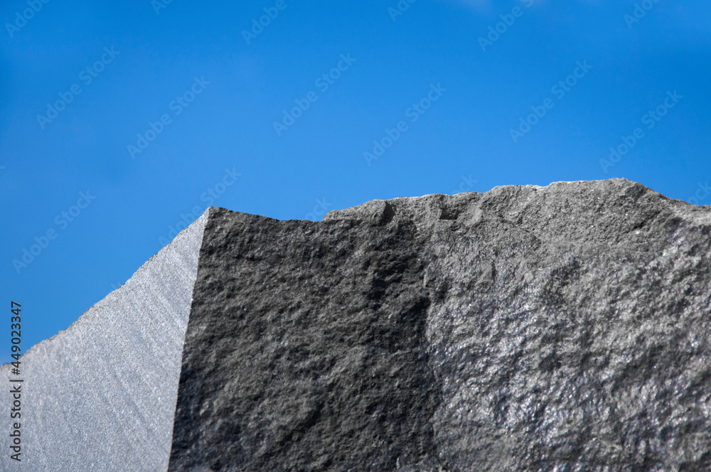 a large block of granite rock against the background of a blue sky. High quality photo a large block of granite rock against the background of a blue sky. High quality photo
